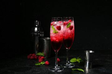 Glasses of fresh raspberry mojito on black background