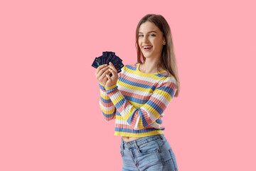 Young woman with credit cards on pink background
