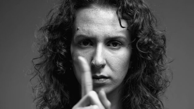 Woman Rejecting Offer with Crossed Hands and Finger Shake, Close-up of Disqualifying Gesture in monochromatic black and white, tight portrait