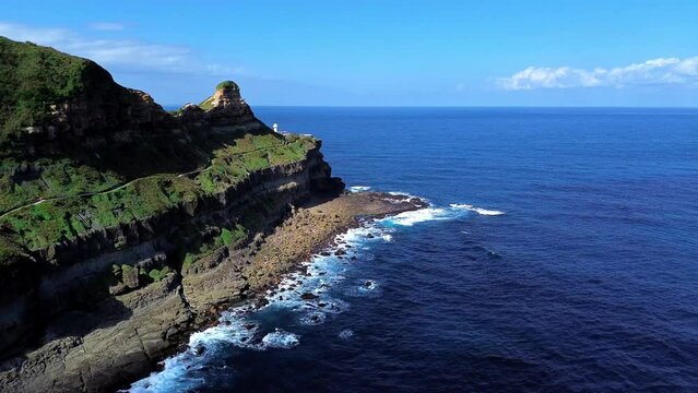 Aerial 4k footage of Bitoujiao lighthouse, a famous scenery of Taiwan northeast corner. Birds eye view in Bitoujiao cape, Ruifang district, New Taipei, Taiwan.