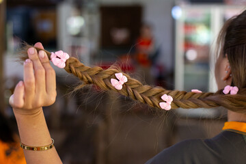 selective focus pink plastic hair accessories in the shape of bows On women's braids, it looks cute.