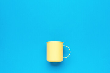Light yellow mug on a blue background.