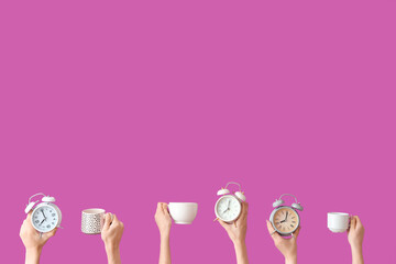 Female hands holding different alarm clocks and cups on purple background