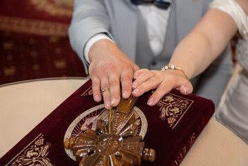 Groom and bride swear with hand on cross and bible faith in marriage, in a church in Romania