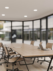 A laptop on a wooden meeting table in a modern spacious meeting room. place of work