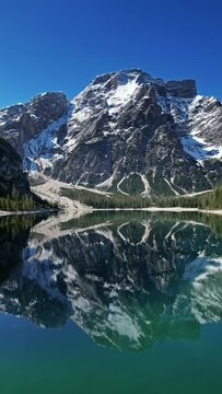 Aerial view of mountain Lago di Braies - Lake Braies in Dolomite Alps, South Tyrol, Italy, Vertical video 4k