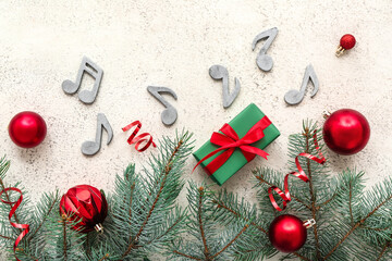 Composition with music signs, Christmas decorations and fir branches on light background