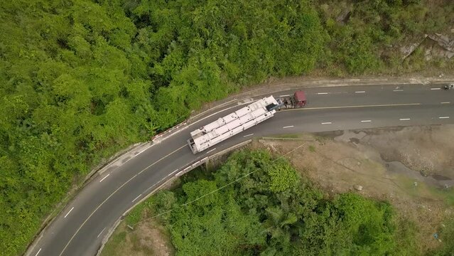 a truck carries an oversized cargo along a mountain road