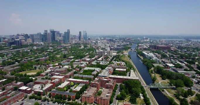 Drone shot following the Lachine Canal, toward the skyline, summer in Montreal