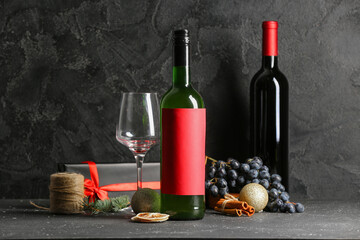 Bottles of wine with glass and Christmas gift box on black background