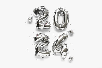 Figure 2024 made of silver foil balloons and Christmas balls on light background