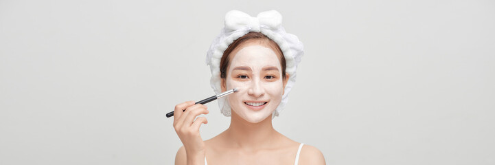 beautiful woman with a brush for make-up and cream on her face. Banner