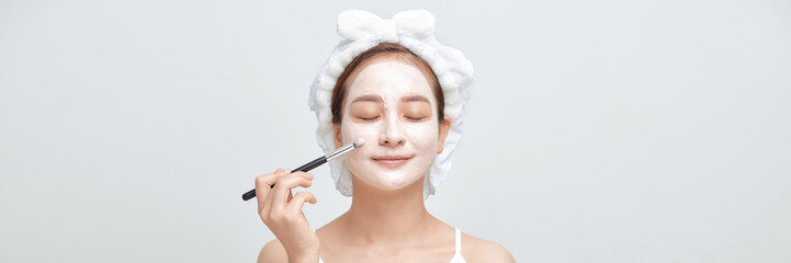 beautiful woman with a brush for make-up and cream on her face. Banner