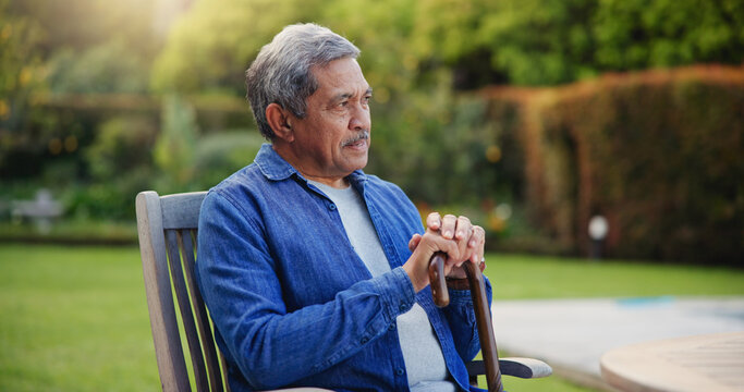 Elderly, man or thinking with cane for retirement, alzheimer and memory outdoor on bench and lonely. Senior, person or walking stick with nostalgia, thoughtful and peace in nature or park with wonder - Powered by Adobe