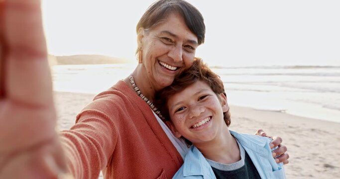 Selfie, beach and face of grandmother with child at sunset on a tropical holiday, vacation or adventure. Happy, smile and senior woman taking picture with boy kid by the ocean or sea on weekend trip.