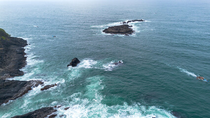 The beauty of Menganti beach, Kebumen, Central Java, Indonesia, a beach with calm sea waves and coral cliffs and green trees