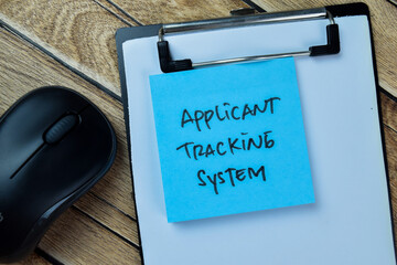 Concept of Applicant Tracking System write on sticky notes isolated on Wooden Table.