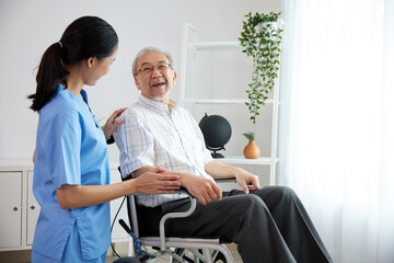 Obraz premium nurse or caregiver beside elderly man sitting on wheelchair at home