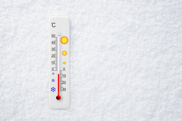 White celsius scale thermometer in snow. Ambient temperature minus 5 degrees celsius