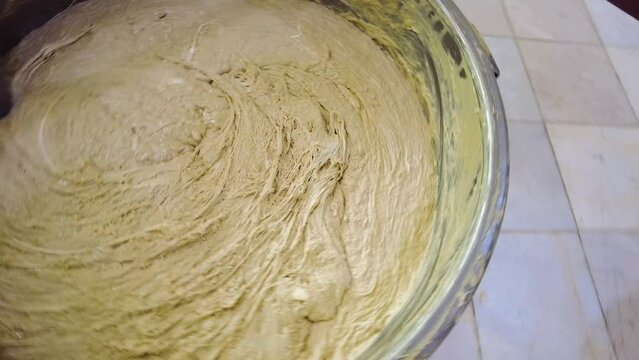 Big Pot of Persian dessert halva tahini sweet mix of sesame syrup grind oil and choobak plant extract in Iran Ardakan Yazd mixer work in factory stirring packaging in local market confectionary 