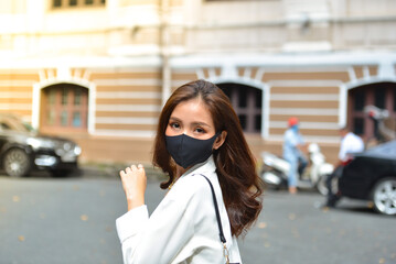 Young woman wearing sunglasses in city, colorful buildings and feel the warm. Exploring this...