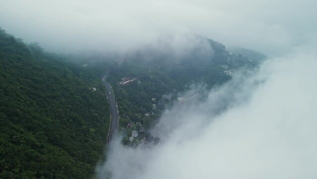 Aerial view of the town in the mountain, Narendra nagar, Tehri Garhwal, Uttarakhand, India. Hilly road in India during a foggy day. Transportation on a hilly Indian road during monsoon. 