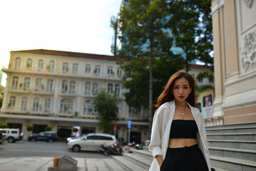 Young woman wearing sunglasses in city, colorful buildings and feel the warm. Exploring this bustling metropolis is a true adventure