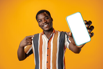 Young african man showing smartphone with isolated screen copy space