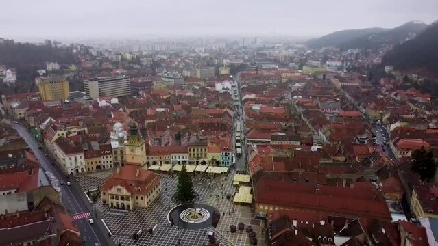 cinematic aerial view of The Council Square or Piața Sfatului and Black church in Brasov, Romania