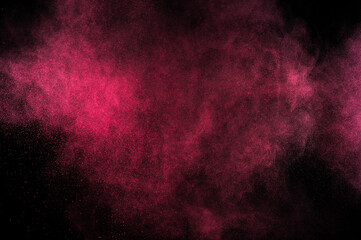 Magenta powder explosion on black background. Pink cloud. Red dust explode. Freeze motion paint Holi.