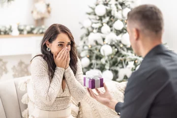 Gordijnen Boyfriend surprises his girlfriend with proposal for Christmas kneeing in front of her © weyo
