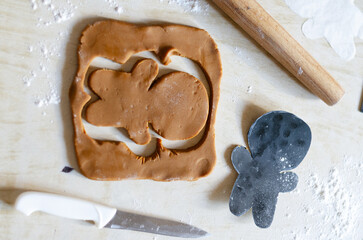 Making homemade Christmas gingerbread cookies. Dough for a gingerbread man on a light table. Shooting Flat lay