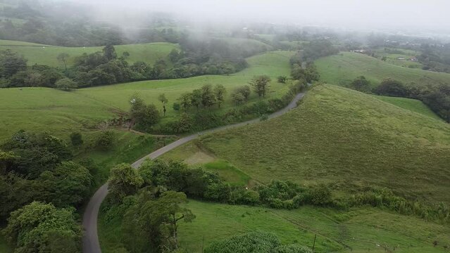 driving through mountains in modern SUV car, drone, driving in foggy green mountains, aerial video