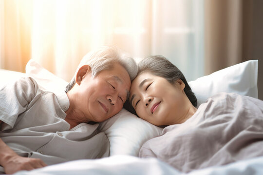 Love lives forever. Senior asian couple at home. Handsome elderly man and attractive old woman are enjoying spending time together while lying in bed.