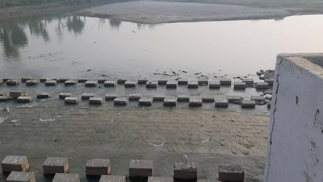 Concrete coastal wave blocker by the sindh river. square-shaped concrete coastal wave blocker. Beautiful view of pull dhole wali layyah pakistan. 4K Footage.