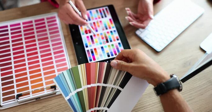 Designer and customer selects color swatch in color palette and on tablet. Choice of shades and color scheme in interior