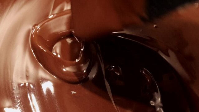 milk chocolate chips in a water bath. Milk (bitter) chocolate galettes sir with silicone spatula