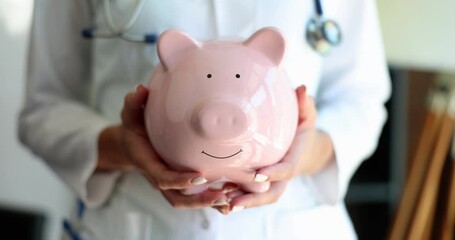 Doctor hands in white coat hold box with piggy bank. Donation of money for healthcare medicine concept