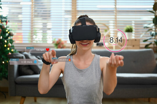 Young sports woman checking checking workout results or progress update on virtual reality glasses