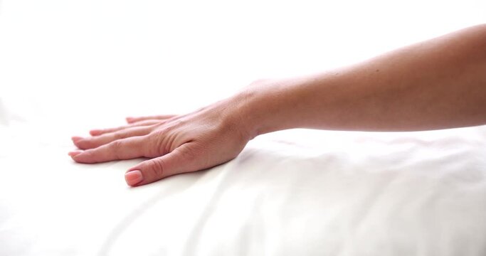 Woman chooses new mattress and bed linen. Woman hand presses mattress to check softness