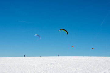 Kitesurfing in the snow with a blue sky