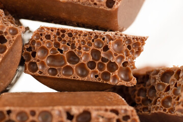 Close-up of milk porous chocolate on a white background.
