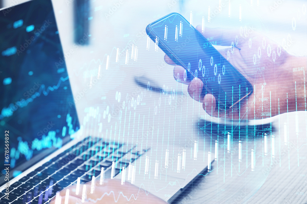 Poster close up of hand using laptop and cellphone at desk with glowing candlestick forex chart on blurry b