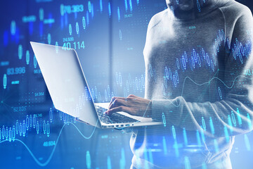 Hacker hands using laptop with glowing candlestick forex chart on blurry office interior background. Stock market and investment concept. Toned image. Double exposure. - Powered by Adobe