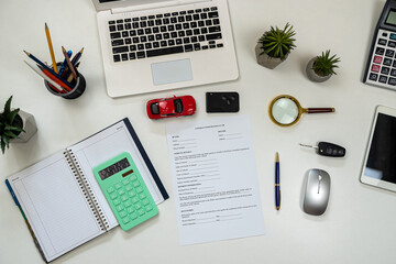 Car signed sales contract on office desk with laptop, pen and calculator