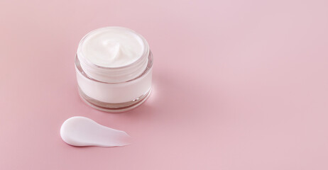 cream jar cosmetic smear cream texture on pastel pink background