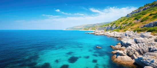 Fototapeta na wymiar Coastline featuring clear blue sky sea and cliffs