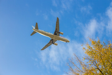 Passenger airplane. Low flying plane on the background of sky. Passenger Airplane Taking Off Into The Blue Sky. Linate Airport. Italia, Lombardia, San Donato Milanese
