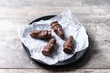 cheerful wrapped chocolate Santa Claus on wooden table