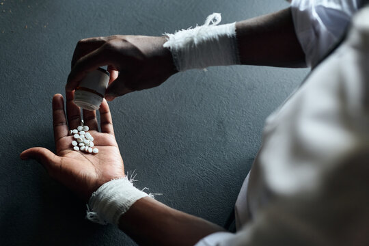 Close-up of young man drinking big dose of pills to commit suicide
